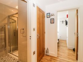 A hallway with wooden doors leading to a bathroom with a shower and a bedroom at Apartment 4 10 Somers Court in Paignton