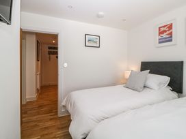 A bedroom with two single beds a lamp on a bedside table and framed pictures on the walls at Apartment 4 10 Somers Court in Paignton