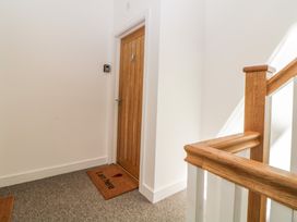 A wooden door with a doormat saying I am here and a wooden stair railing near the door at Apartment 4 10 Somers Court in Paignton