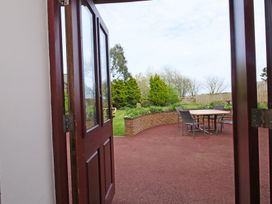 An outdoor garden view with a table and chairs at Chomley @ Summerfield Farm in Hawsker