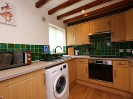 A kitchen with a washing machine and microwave at Chomley @ Summerfield Farm in Hawsker