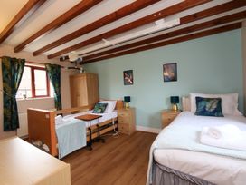 A bedroom with two beds and a wardrobe at Chomley @ Summerfield Farm in Hawsker