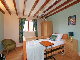 A bedroom with a bed and a bedside table at Chomley @ Summerfield Farm, Hawsker