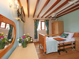 A bedroom with a hospital bed and mirror at Chomley @ Summerfield Farm in Hawsker