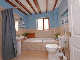 A bathroom with a bath tub, sink and toilet at Chomley @ Summerfield Farm in Hawsker