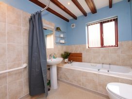A bathroom with a bathtub, sink, and shower at Chomley @ Summerfield Farm in Hawsker