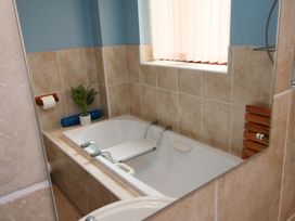 A bathroom with a bath tub and a towel holder at Chomley @ Summerfield Farm, Hawsker