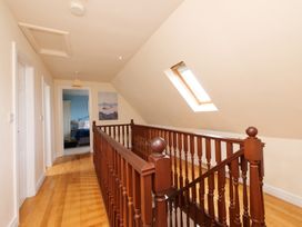 A hallway with a wooden stair railing and skylight at Chomley @ Summerfield Farm in Hawsker