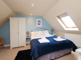 A bedroom with a bed and wardrobe at Chomley @ Summerfield Farm in Hawsker