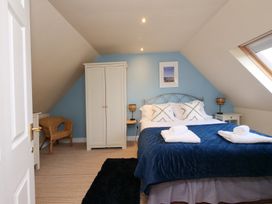A bedroom with a bed and wardrobe at Chomley @ Summerfield Farm in Hawsker