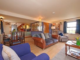 A living room with a sofa and dining area at Albany @ Summerfield Farm in Hawsker