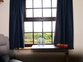 A living room with a window and a table at Albany @ Summerfield Farm Hawsker