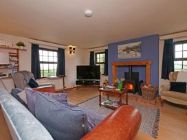 A living room with a sofa, armchair, and television at Albany @ Summerfield Farm Hawsker