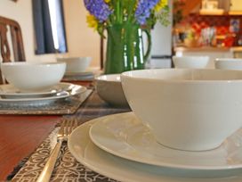 A dining table set with plates and bowls at Albany @ Summerfield Farm in Hawsker