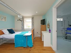 A bedroom with a bed and television at Albany @ Summerfield Farm Hawsker