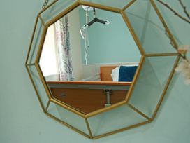 A mirror reflecting a hospital bed with a curtain in a bedroom at Albany @ Summerfield Farm Hawsker
