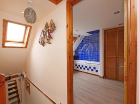 A bathroom with a bathtub and blue tiles at Albany @ Summerfield Farm, Hawsker