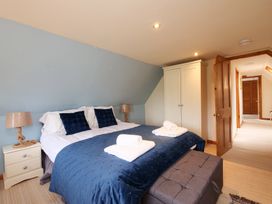 A bedroom with a bed and wardrobe at Albany @ Summerfield Farm in Hawsker