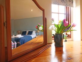 A bedroom featuring a mirror, bed, and a vase with flowers at Albany @ Summerfield Farm, Hawsker