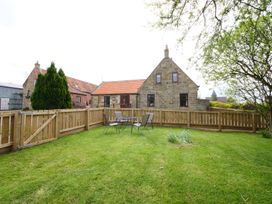 A fenced garden with a table and chairs at Albany @ Summerfield Farm in Hawsker