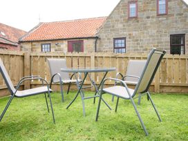 A garden with a table and chairs at Albany @ Summerfield Farm in Hawsker