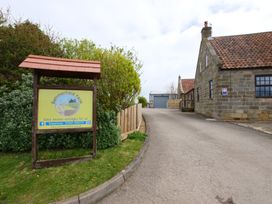 A farm entrance with a sign and a building at Albany @ Summerfield Farm, Hawsker