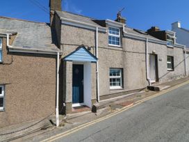 A house with a blue door and windows at 4 Bryn Llan in Aberdaron