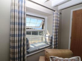 A living room with a window and cushions at 4 Bryn Llan in Aberdaron