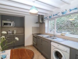 A kitchen with cabinets and appliances at 4 Bryn Llan in Aberdaron