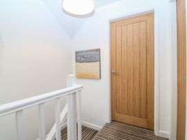 A hallway with a staircase and doors at 4 Bryn Llan Aberdaron