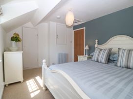 A bedroom with a bed and bedside lamp at 4 Bryn Llan in Aberdaron