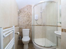 A bathroom with a shower, toilet, and sink at 4 Bryn Llan in Aberdaron