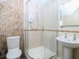 A bathroom with a shower, toilet, and sink at 4 Bryn Llan in Aberdaron