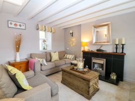 A living room with a sofa and coffee table at 5 Bryn Llan in Pwllheli