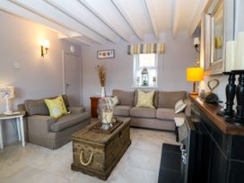 A living room with a sofa and a coffee table at 5 Bryn Llan in Pwllheli