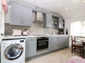A kitchen with appliances and furniture at 5 Bryn Llan in Pwllheli