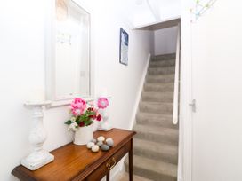 A hallway with a table and stairs at 5 Bryn Llan in Pwllheli