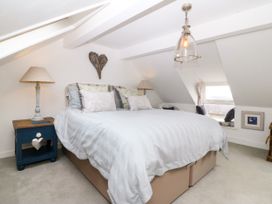 A bedroom with a double bed and bedside table at 5 Bryn Llan in Pwllheli