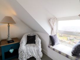 A snug with a chair and lamp at 5 Bryn Llan in Pwllheli
