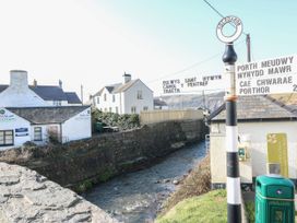 A street view with a signpost and river at 5 Bryn Llan in Pwllheli