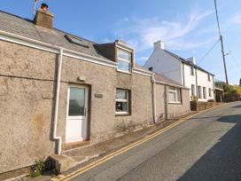 A house on a street with a door and windows at 5 Bryn Llan in Pwllheli