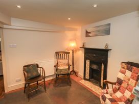 A living room with a fireplace and seating at Bridge End Cottage Haverthwaite near Cartmel