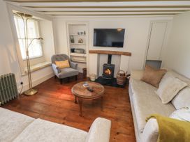 A living room with a fireplace and a television at Bridge End Cottage Haverthwaite near Cartmel