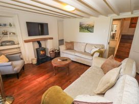 A living room with a fireplace and television at Bridge End Cottage Haverthwaite near Cartmel