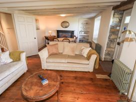 A living room with a sofa, coffee table, and fireplace at Bridge End Cottage Haverthwaite near Cartmel
