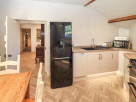 A kitchen with a refrigerator and sink at Bridge End Cottage Haverthwaite near Cartmel