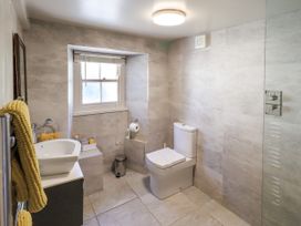 A bathroom with a sink, toilet, and shower at Bridge End Cottage in Haverthwaite near Cartmel