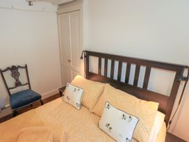 A bedroom with a bed and a chair at Bridge End Cottage Haverthwaite near Cartmel