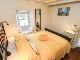 A bedroom with a bed and window at Bridge End Cottage, Haverthwaite near Cartmel