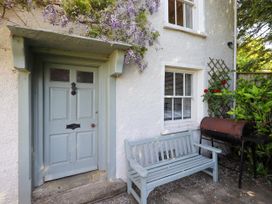 An outdoor view of a door and bench at Bridge End Cottage Haverthwaite near Cartmel